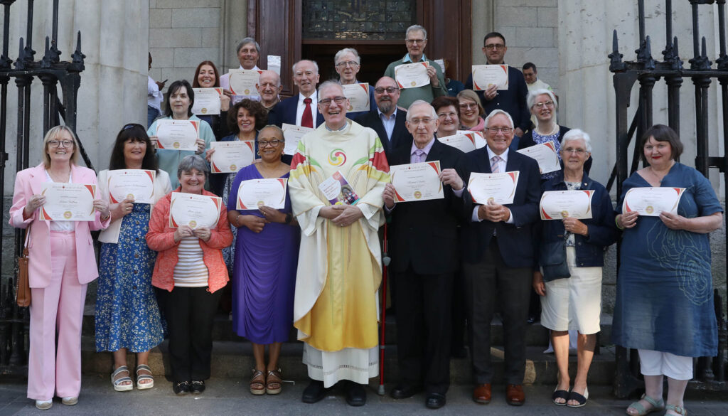 Graphic of Presentation of Pathways certificates where people are on the streps holding certificates and Fr. Gareth Byrne is in the middle in his yellow, green and red robe. Everyone is smiling at the camera.