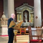 Graphic of a man reading from the stand on the altar to the congregation.