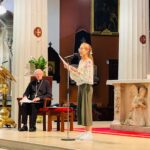 Graphic of a woman speaking to the congregation from the altar through a microphone.
