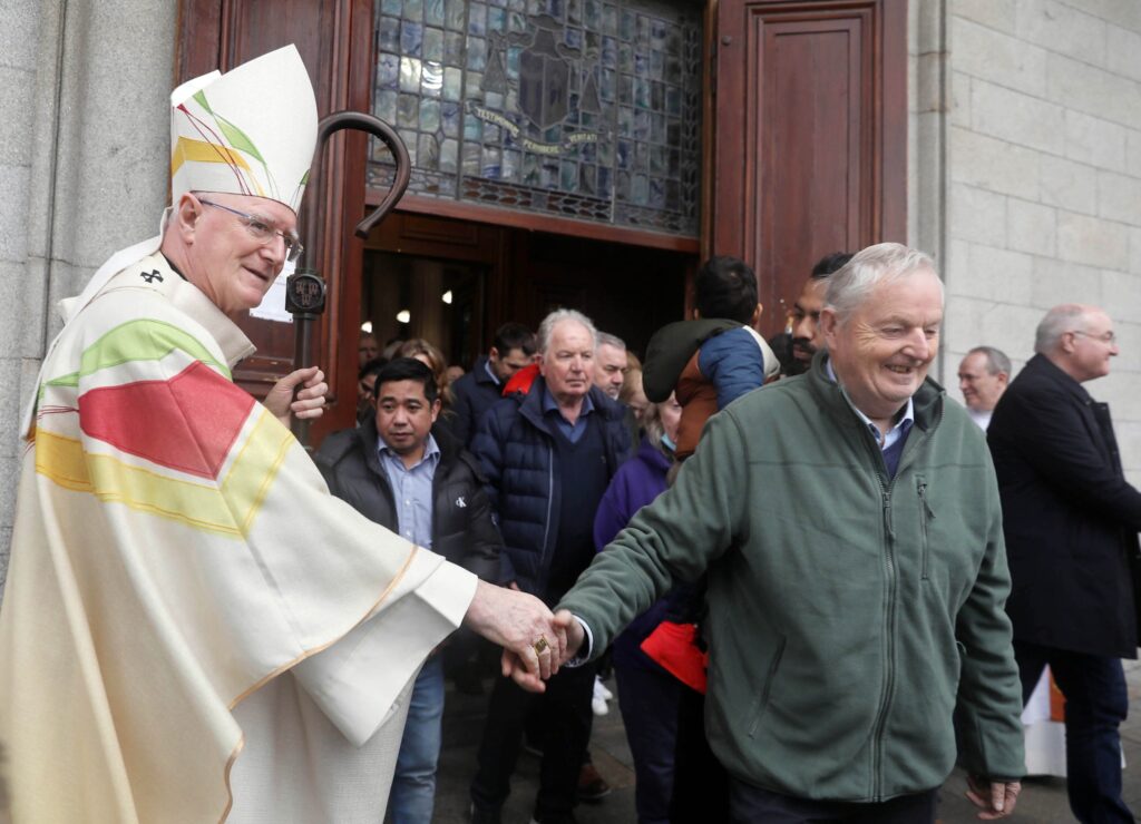 Graphic of a man shaking Archbishop Farrell's hands walking out from the church with the congregation,