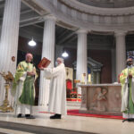 Graphic of Archbishop Farrell being presented with a book by a priest with His Excellency Archbishop Jude Thaddeus Okolo, Apostolic Nuncio to Ireland in the background.