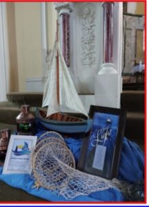 Graphic of the Parish Synod display called the Howth- Synod- Display which has a fishing trap, a model sailboat and some framed Synod prayers.