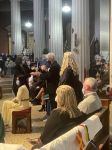 Graphic of a group of people gathered in church with a woman receiving an object from a man.