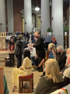 Graphic of a group of people gathered in church with a woman receiving an object from a man.