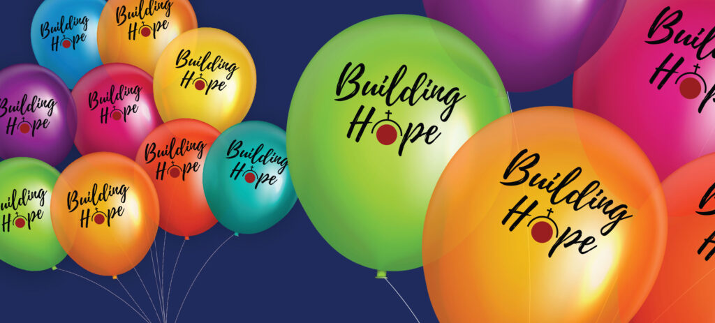 Graphic of a group of different colours of balloons on a dark blue background with the words "Building Hope" inscribed on them.