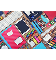 A graphic showing some stationery such as Sellotape, highlighters. a calculator, colours and notebooks on a table. There is also a tablet in the middle of the table and a white keyboard to the left of the graphic.