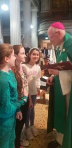 Graphic for the Opening Liturgy for the Diocesan Synodal Pathway. Graphic shows Archbishop Dermot Farrell bending over to talk to three young girls.