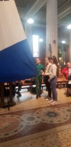 Graphic for the Opening Liturgy for the Diocesan Synodal Pathway. Graphic shows a blue and white flag in the left side of the photo with three young children standing towards the blue and white in the middle of the photo.