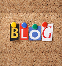 Graphic of a brown background with the letter B in yellow on a black background the letter L in white on red background the letter O in white on a blue background and the letter G in red on a white background making the word Blog. The letters are stuck with thumbtacks in the colours yellow ,blue, green and red.