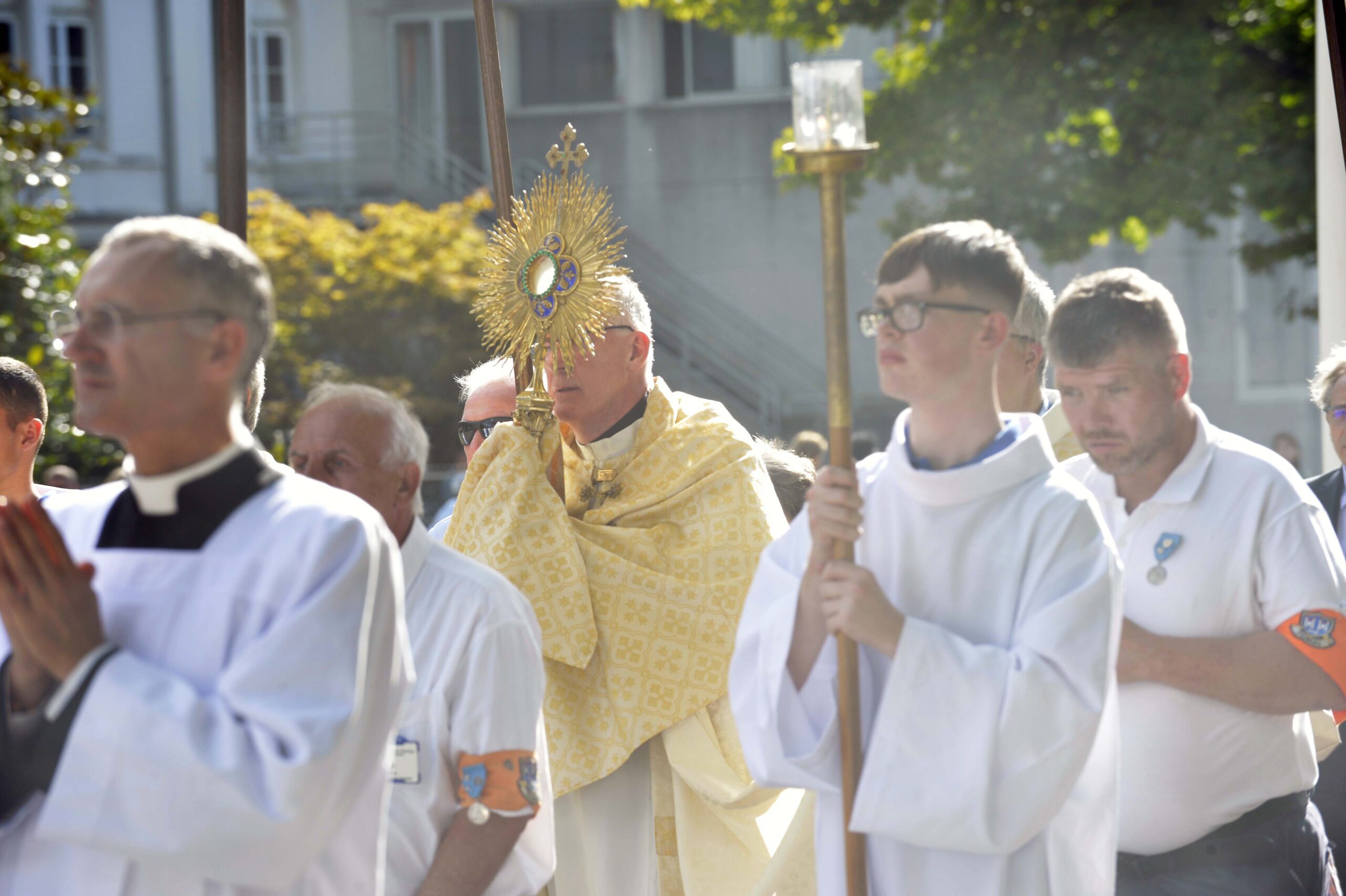 Graphic for the pilgrimages page which depicts members of the clergy walking with an archbishop in their uniforms with other people following them on a pilgrimage.