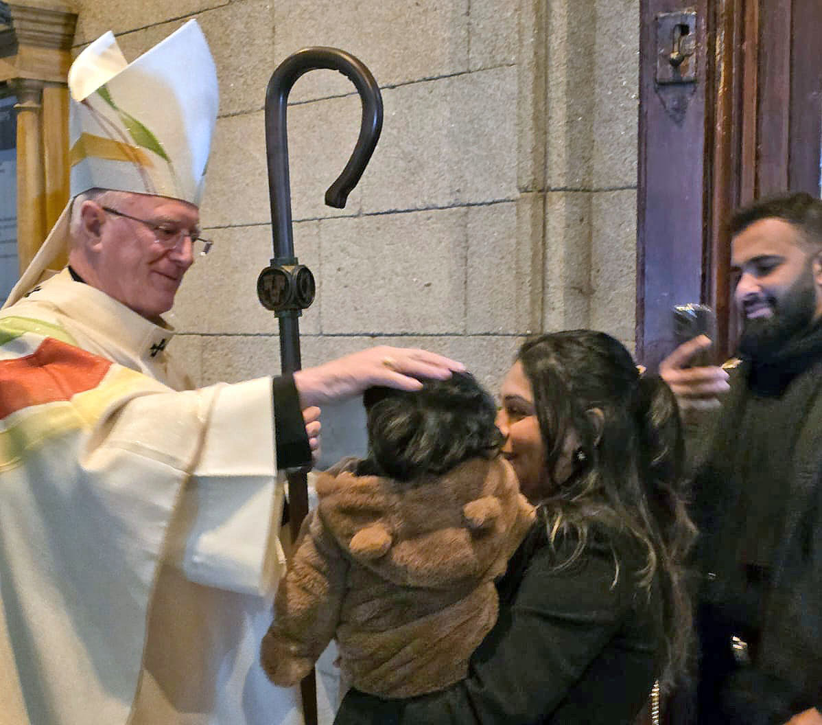 Archbishop Farrell welcoming a family to the service